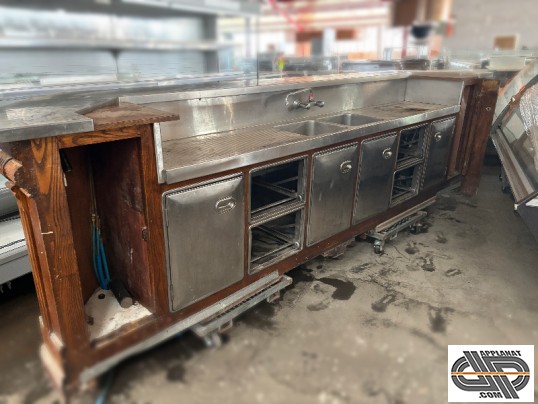 Vue générale de l'arrière d'un comptoir de bar d'occasion , vendu avec rénovation incluse , on y voit le plan de travail inox et la réserve réfrigérée