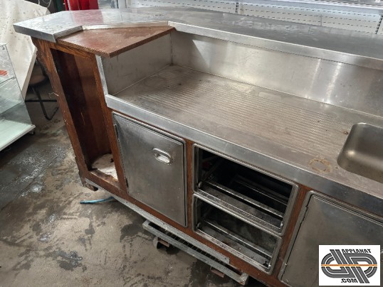 Partie arrière gauche du comptoir de bar , on y voit la piste de service inox et l'égouttoir à gauche de l'évier, ainsi que le soubassement réfrigéré